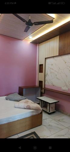 a room with a bed and a table in it at Hari Har HOME STAY FULLY AC in Ujjain