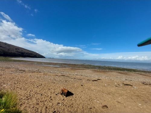 a rock sitting on a sandy beach near the ocean at The Garden Room at Poplar Cottage - Weston-super-Mare in Wick Saint Lawrence