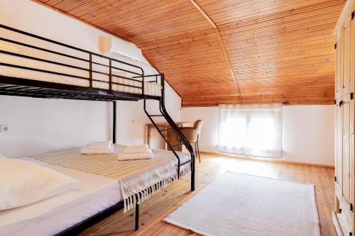 a bedroom with two bunk beds and a wooden ceiling at Кума Лиса in Devin