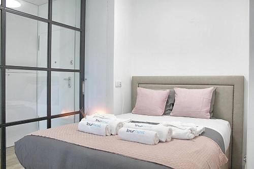 a bed with three towels sitting on top of it at Arrábida Luxury Studio in Vila Nova de Gaia