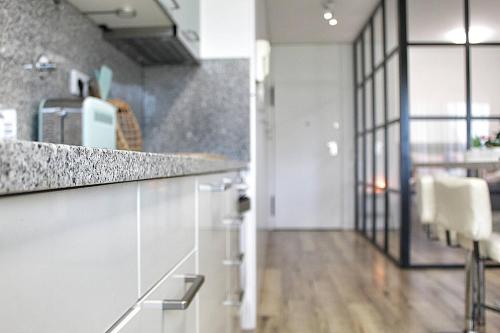 a kitchen with white cabinets and a counter top at Arrábida Luxury Studio in Vila Nova de Gaia