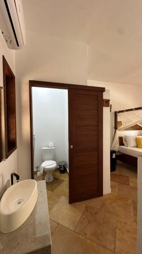 a bathroom with a toilet and a sink at villa coqueiro praia do prea in Cruz