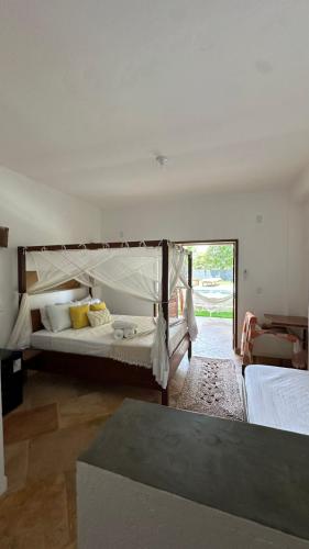 a bedroom with a large bed with a canopy at villa coqueiro praia do prea in Cruz
