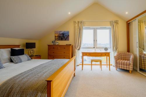 a bedroom with a bed and a desk and a chair at 6 The Salterns - Yarmouth in Freshwater