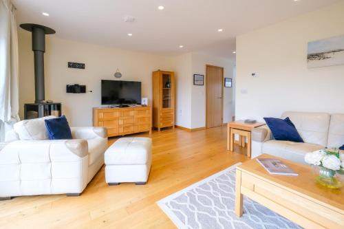 a living room with white furniture and a flat screen tv at 6 The Salterns - Yarmouth in Freshwater