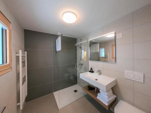 a bathroom with a sink and a shower and a mirror at Camere Osteria Bäkar, Val Bedretto in Bedretto