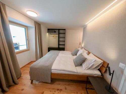 a bedroom with a bed in a room with a window at Camere Osteria Bäkar, Val Bedretto in Bedretto
