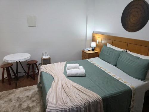 a bedroom with a bed with two towels on it at Flat 108B com lazer próx ao centro in Serra Negra