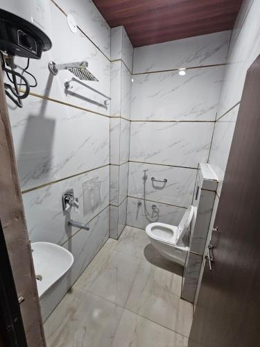 a bathroom with a toilet and a sink at Hotel Maharaja Path in Ujjain