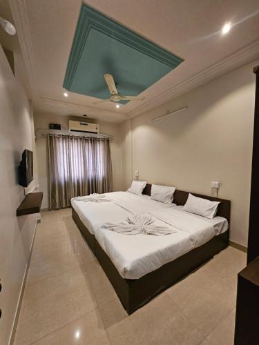 a bedroom with a large bed with a green ceiling at Hotel Maharaja Path in Ujjain