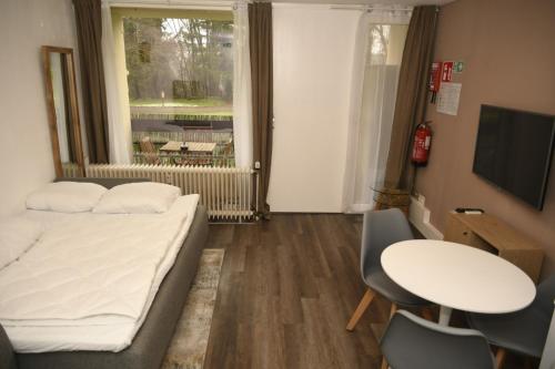 a room with a bed and a table and a window at Maison-Home-ZuHause in La Calamine