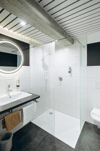 a white bathroom with a sink and a toilet at Hotel Scholz in Aalen