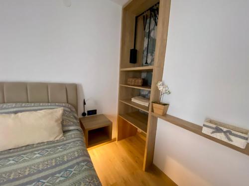 a bedroom with a bed and a book shelf at Apartmani Perić in Stari Grad