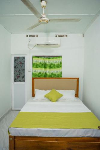 a bedroom with a bed with a green blanket at lagoon holiday villa Jaffna in Tavadi