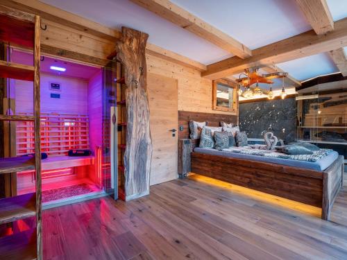 a room with a bed in a room with wooden walls at Bergromantik Ferienwohnung Harmonie mit Sauna, Whirlpool und Bergblick in Marktschellenberg