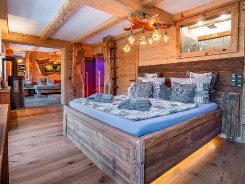 a bedroom in a log cabin with a large bed at Bergromantik Ferienwohnung Harmonie mit Sauna, Whirlpool und Bergblick in Marktschellenberg