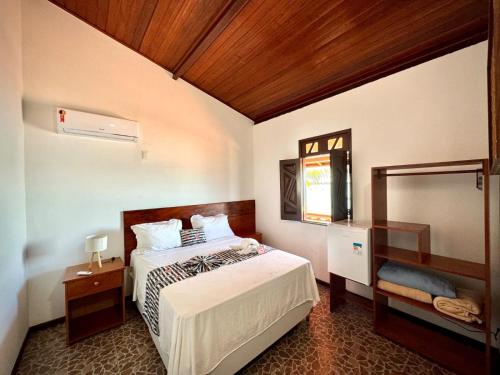a bedroom with a bed and a mirror at POUSADA TOCA DO LOBO in Ilha de Boipeba