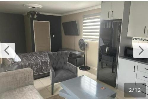 a bedroom with a bed and a chair and a desk at Lemao guesthouse in Johannesburg