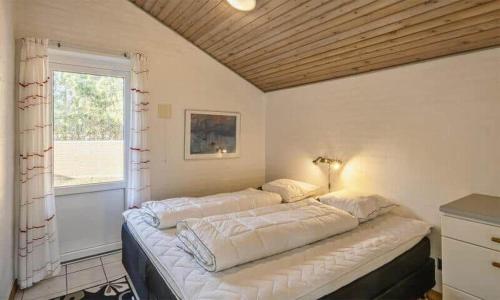a large bed in a room with a window at VE400-Vejers-Strand-Engesovej-52 in Vejers Strand