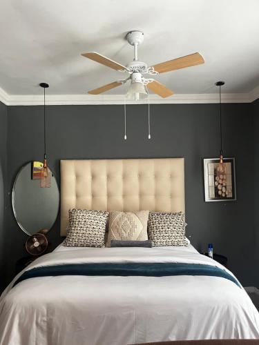 a bedroom with a bed with a ceiling fan at Bird Song in Roodepoort
