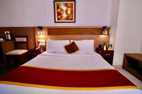 a bedroom with a large white bed in a room at Hotel De Grand Malabar in Kozhikode