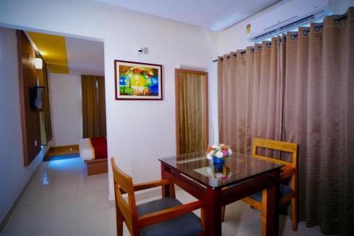 a room with a table and chairs in a room at Hotel De Grand Malabar in Kozhikode