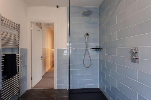 a bathroom with a shower with blue tiles at Didis Cottage-Dog Friendly-Garden-Cowes-Sleeps 4 in Cowes