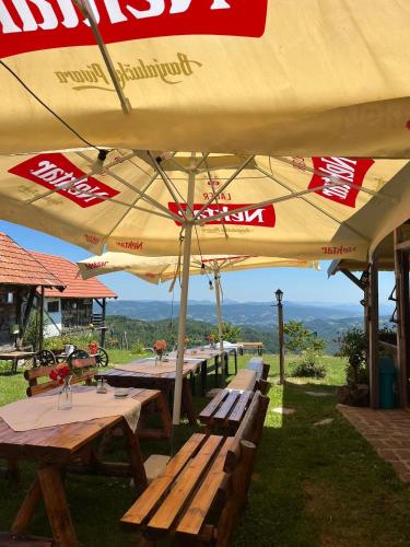 a group of picnic tables under an umbrella at Šebovina Jelova gora in Starčevići