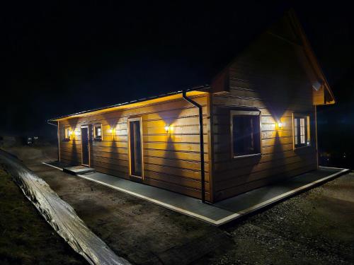 a house with lights on the side of it at night at Dom na słodkim wzgórzu in Trzebinia