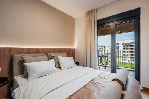 a bedroom with a bed and a large window at APART 28 - Premium Suites in Podgorica