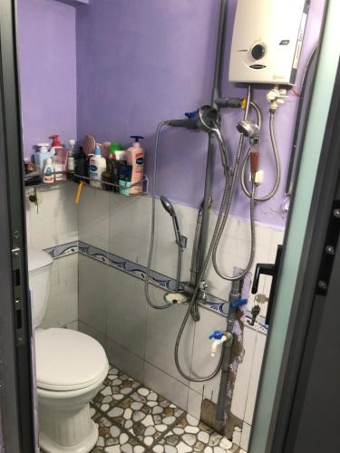 a bathroom with a toilet and a shower in it at homestay Huynh DC in Ho Chi Minh City