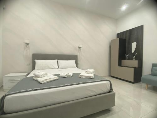 a bedroom with a bed with two towels on it at NOGA rooms in Porto Cesareo