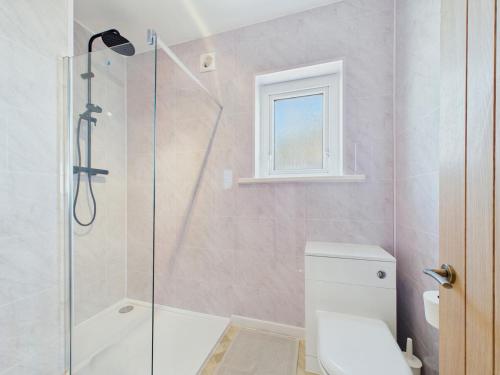 a bathroom with a shower and a toilet and a window at Southbourne beach in Southbourne