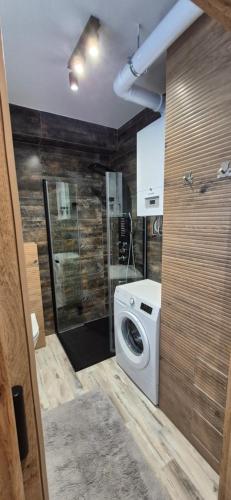a bathroom with a washing machine in a room at Izzy Apartament in Myślenice