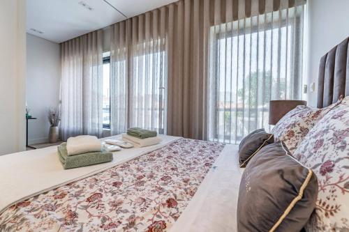 a bedroom with a large bed with a large window at Antas Park Flat With Pool in Porto