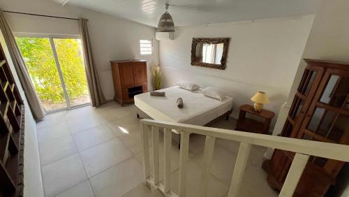 a white bathroom with a sink and a mirror at Moorea - Temae Reef Cottage in Temae