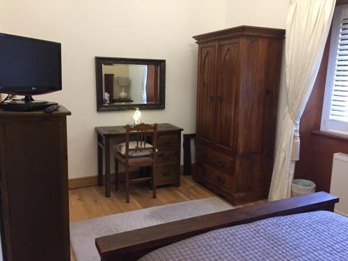 a bedroom with a bed and a dresser and a mirror at Waters Edge Cottage in Alexandria
