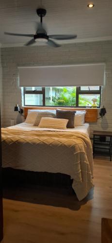 a bedroom with a large bed with a large window at Studio 149 - Wild Coast Accommodation in Sunrise-on-Sea