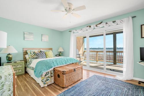 a bedroom with a bed and a balcony at Channel Winds - Waterfront Bliss & Lighthouse Views! in Birch Town