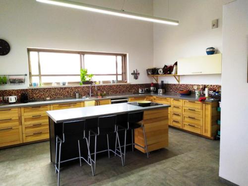 a kitchen with wooden cabinets and a white counter top at Villa Bougainvillea in Ashalim