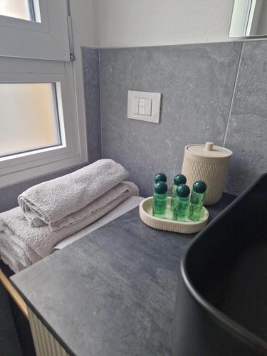 a bathroom with a counter with four green bottles on it at House 13 apartment in Cernobbio in Cernobbio