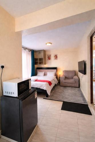 a large bedroom with a bed and a couch at AceStudio Kikuyu with Parking and Lift in Kikuyu
