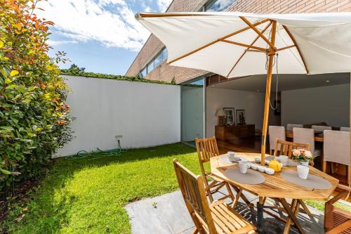 a wooden table with an umbrella in a yard at Quinta da Barca Golf in Gandra