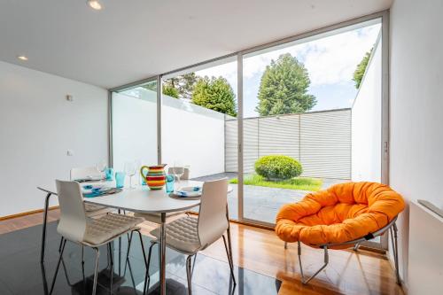 a dining room with a table and chairs and a large window at Quinta da Barca Golf in Gandra