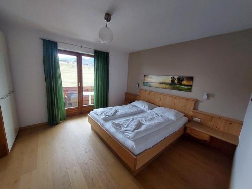 a bedroom with a bed and a large window at Alpen Appartements in Embach