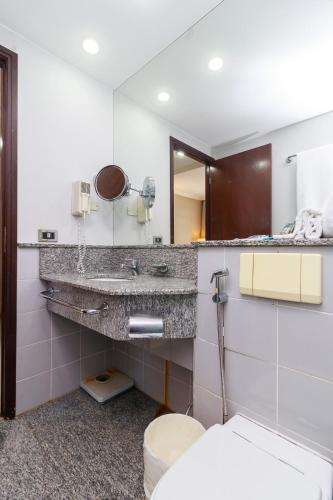 a bathroom with a sink and a toilet and a mirror at Flat Luxo Verbo Divino 6 in São Paulo