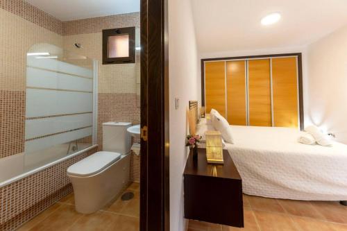 a bathroom with a bed and a tub and a toilet at Collados Experience Piscina y Parking in Águilas