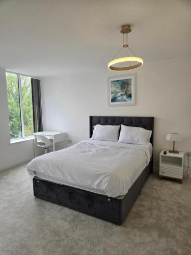 a bedroom with a large bed and a lamp at Glams luxury home in Wolverhampton