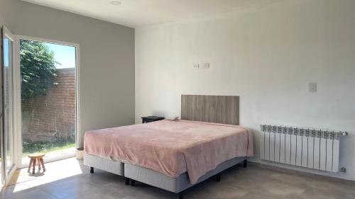 a bedroom with a bed and a large window at Mi casa es tu casa Loft in Malargüe