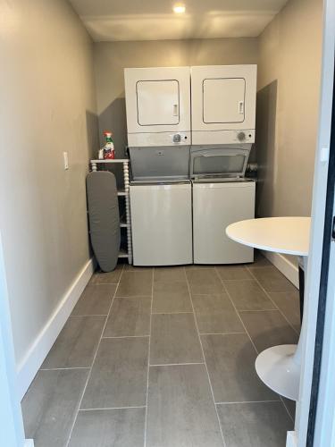a small kitchen with white appliances and a table at The Dex at Coconut Cove in Fort Myers Beach